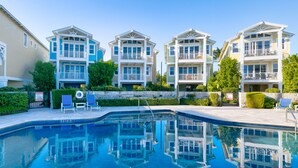 Un edificio residencial con piscina, varios balcones y cielo despejado.