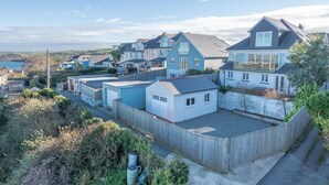 Et kystnære boligområde med huse, et træhegn og fri udsigt til havet.