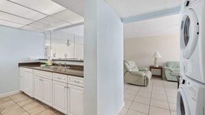A modern kitchen with white cabinets, a large island, and a built-in oven. - Moondriter 606 - Beach Front Condo (Panama City Beach)