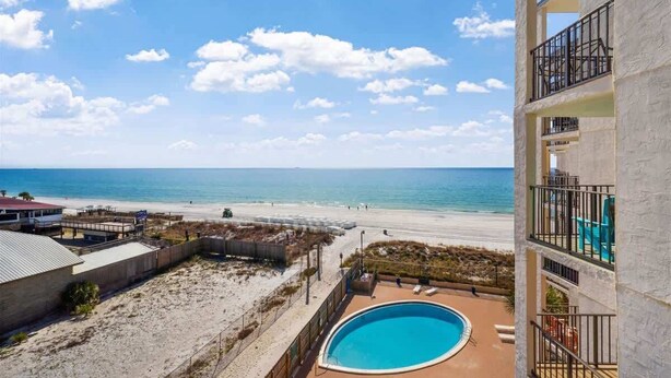 A beachfront hotel with a pool, beach access, and a view of the ocean. - Moondriter 606 - Beach Front Condo (Panama City Beach)