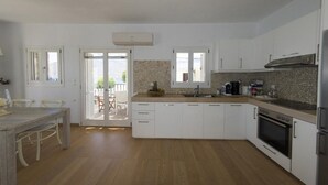 Eine moderne Küche mit weißen Schränken, einer Holzarbeitsplatte und einem eingebauten Backofen.
