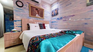 Un dormitorio con cama, mesita de noche, cómoda, reloj y un cuadro en la pared.