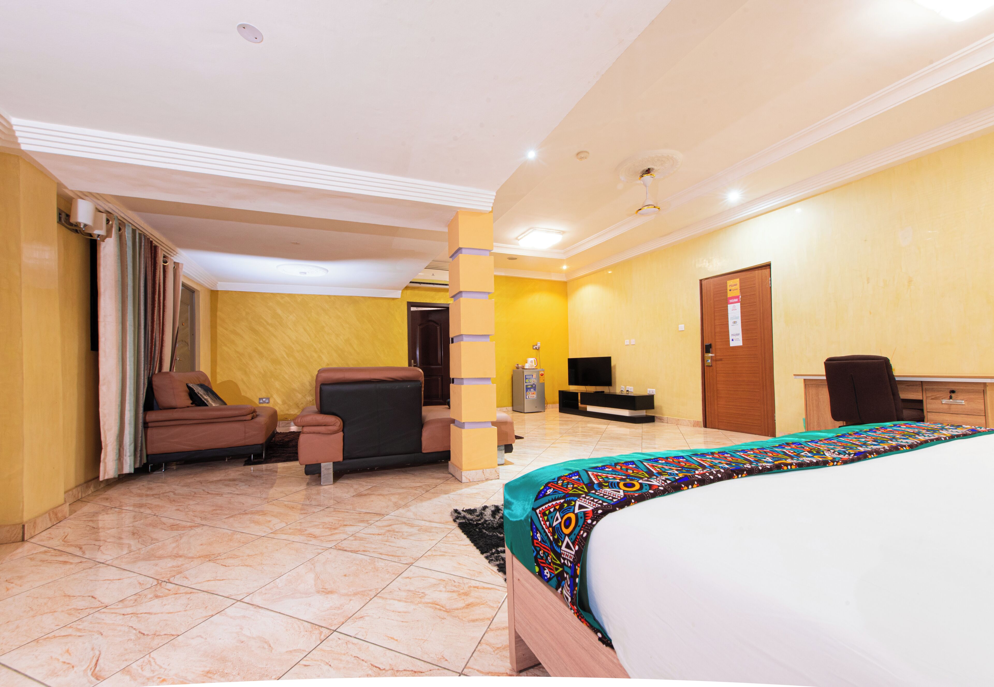 Habitació d'hotel amb llit, sofà, escriptori i televisió.