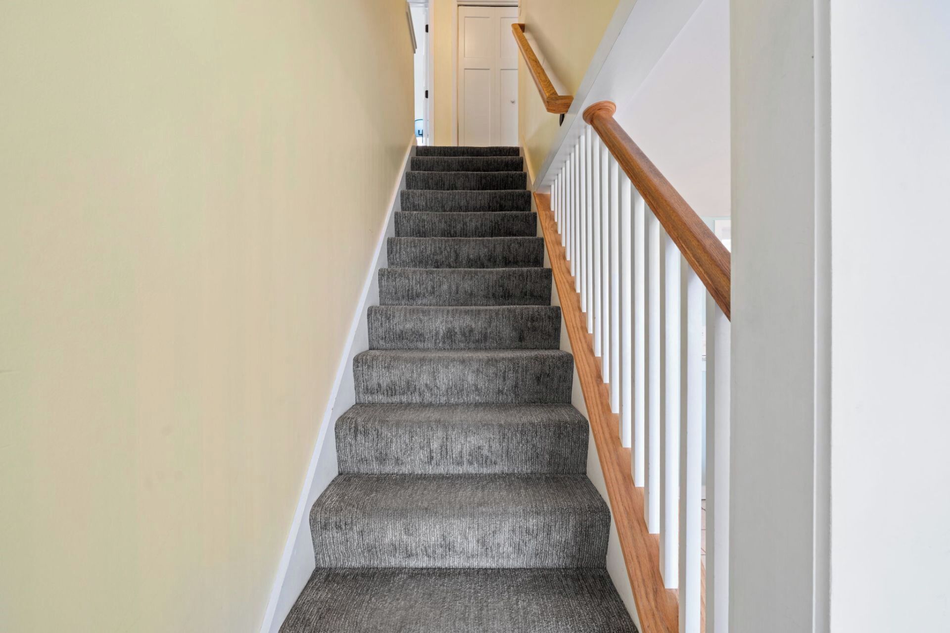 Eine Treppe mit Teppichbelag und hölzernen Geländern.