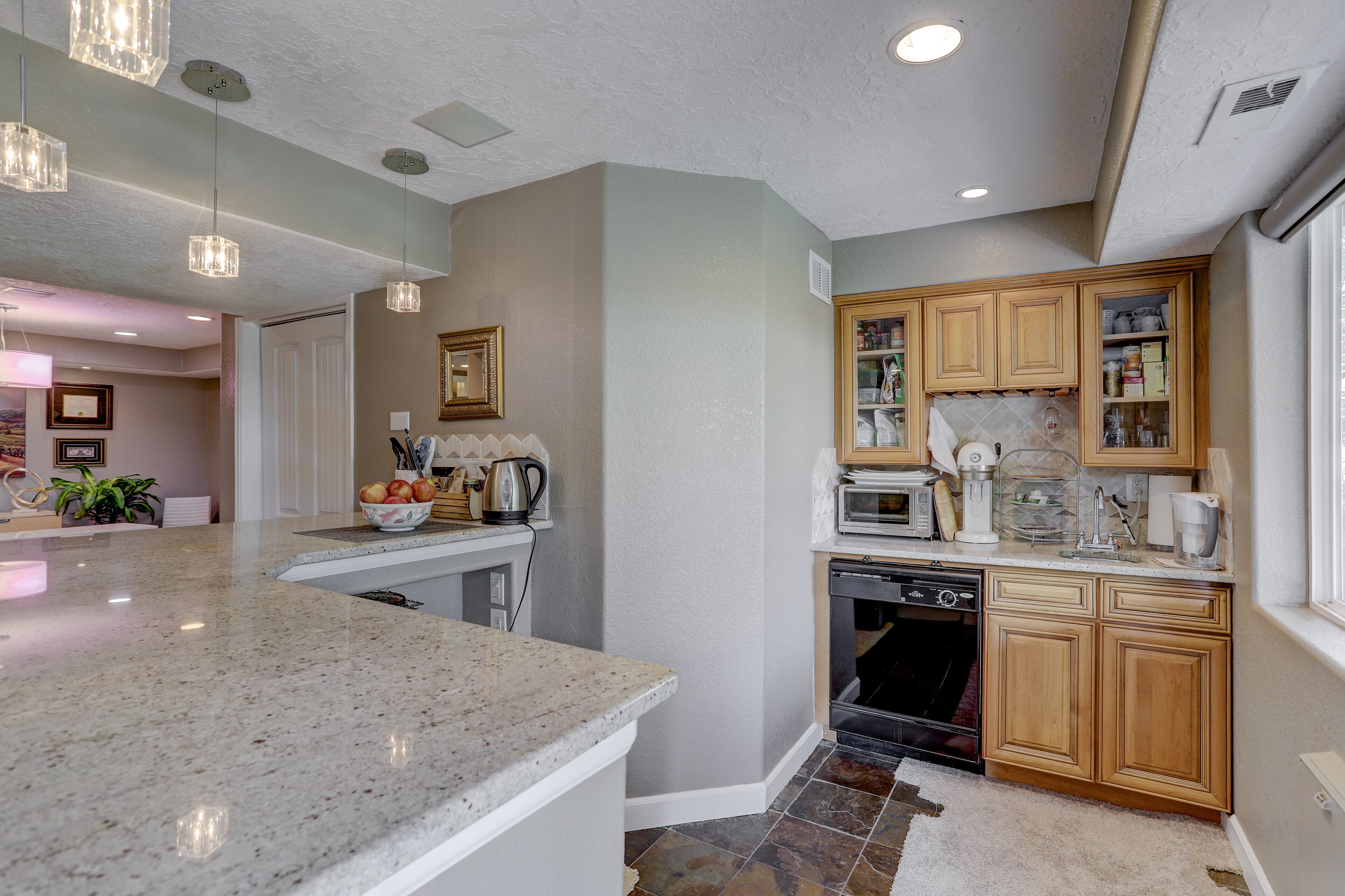 A modern kitchen with granite countertops, wooden cabinets, and built-in appliances.