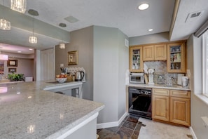 A modern kitchen with granite countertops, wooden cabinets, and built-in appliances.