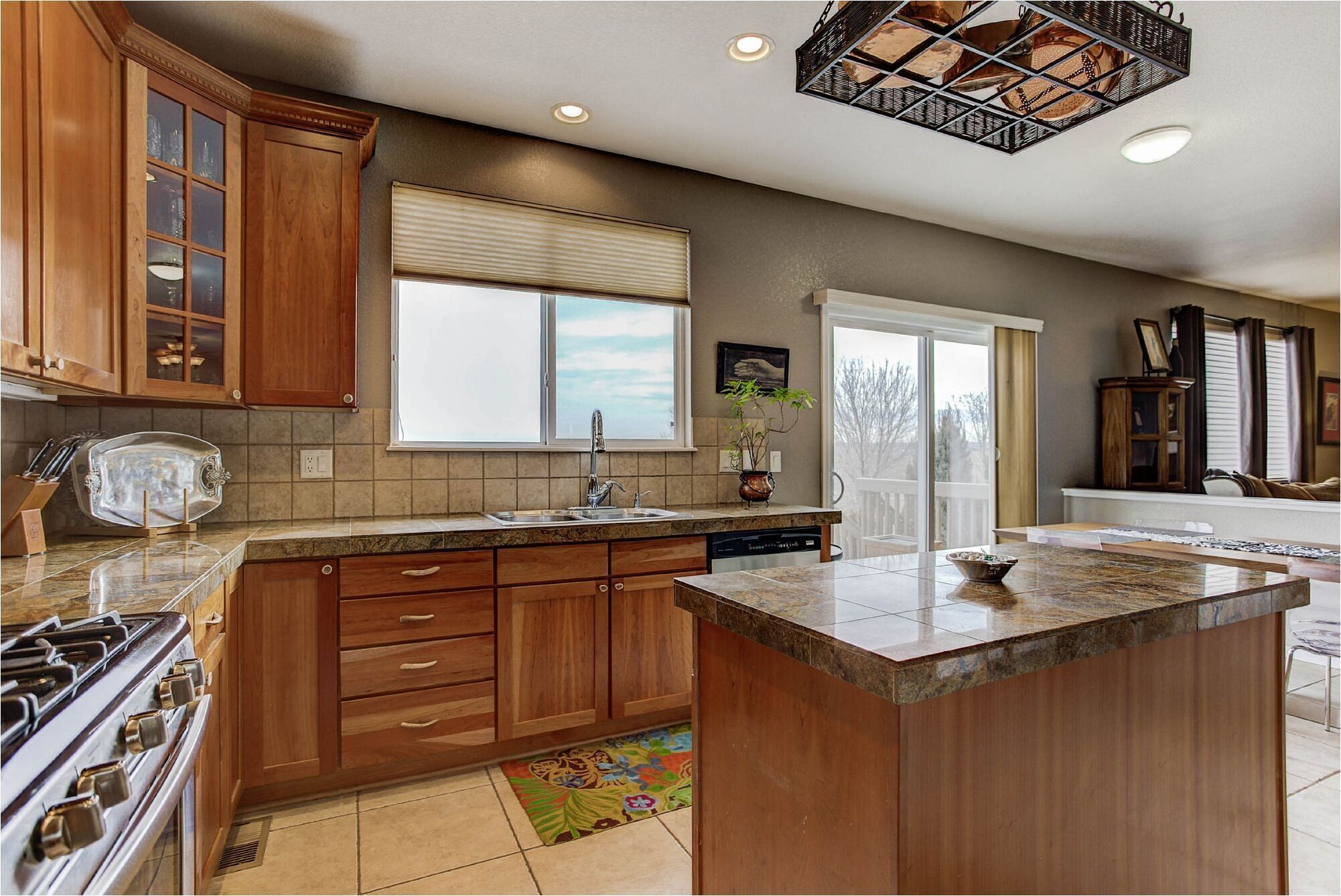 A kitchen with wooden cabinets, a large window, and a central island.