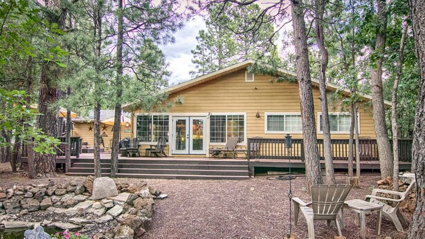 A lodge with a covered patio, outdoor seating, and a stone pathway leading to the entrance. - Perfect Pinetop Getaway; 2 Master Suites; Wifi, Satellite; Hot tub, Dog Friendly (Pinetop)