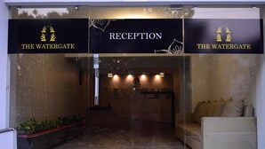 Un espace d’accueil doté d’une porte vitrée, d’un comptoir de réception et d’un canapé.