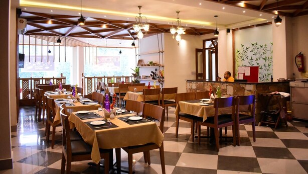 Un restaurant avec de nombreuses tables et chaises, un sol à carreaux et un coin bar.