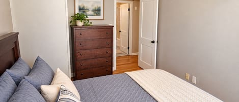 Une chambre à coucher avec un lit, une commode et un ventilateur de plafond.