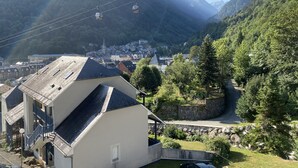 A mountain town with a cable car system, a church, and a residential area with a stone wall and greenery. - Cauterets beautifull duplex apartment with terrace (Cauterets)