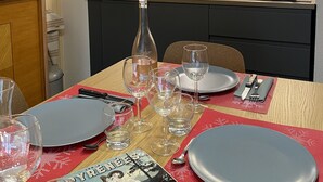 A modern kitchen with dark cabinets, a wooden countertop, and a dining area set for a meal. - Cauterets beautifull duplex apartment with terrace (Cauterets)