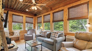 A cozy cabin interior with a sofa, armchair, and a small table. - Welcome to Charming Get-A-Way – Your Ultimate Escape!

 (Burnside)