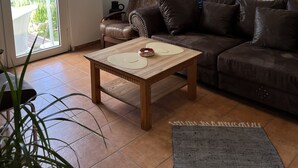A living room with a brown leather sofa, a wooden coffee table, and a grey rug. - Eldehof, Oldag family (Wredenhagen)