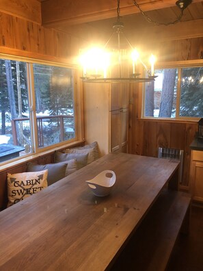 Cozy cabin-style interior with a long dining table and cabinet.