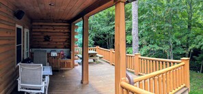 A wooden deck with outdoor seating and a grill area. - "Rushing Bear!" Fully furnished two bedroom cozy cabin you want to capture!" (Maggie Valley)