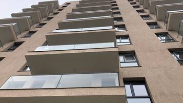Un edificio alto con varios balcones y ventanas rectangulares.