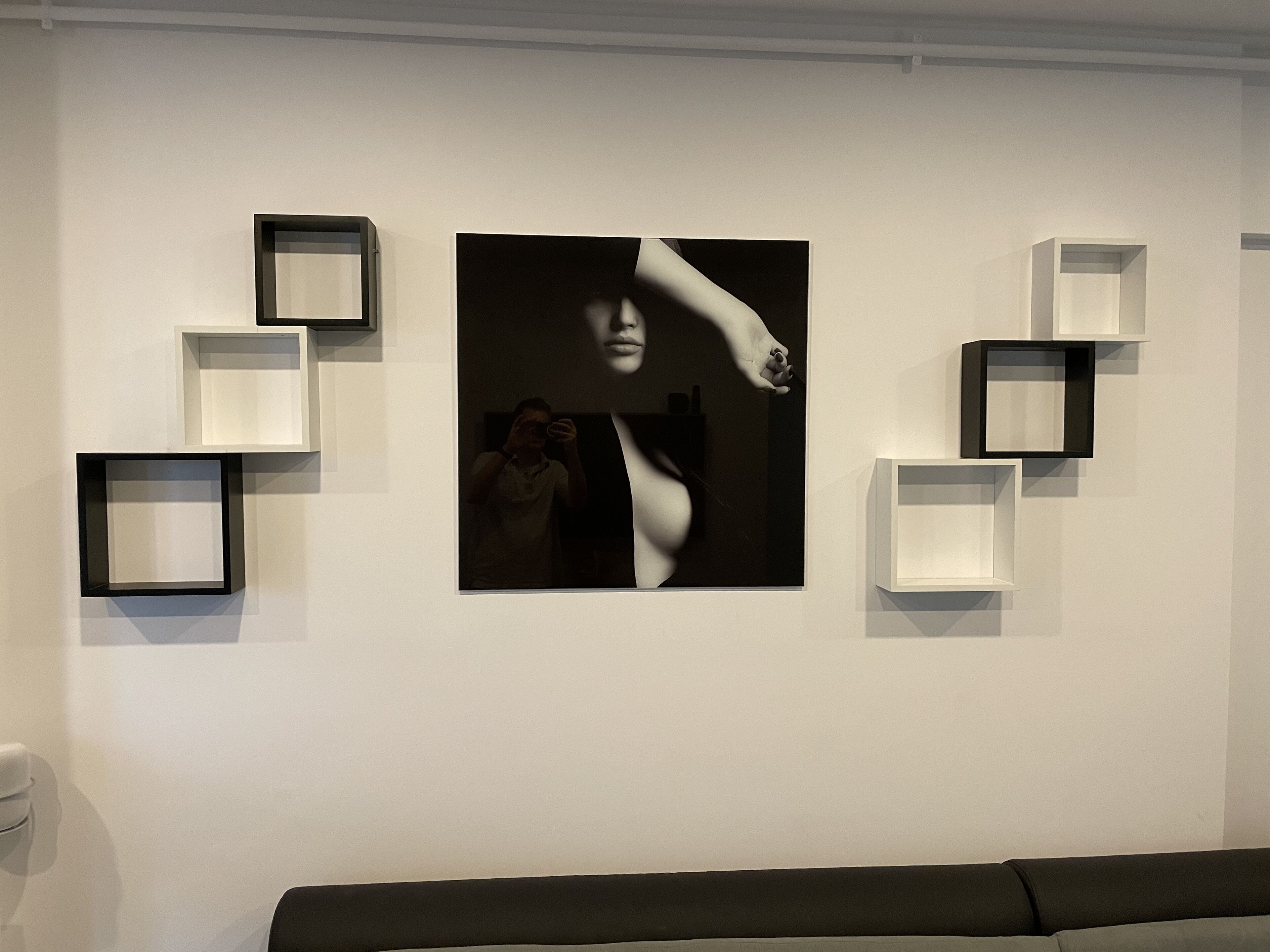 Eine Wand mit einem großen gerahmten Foto und mehreren leeren Bilderrahmen.