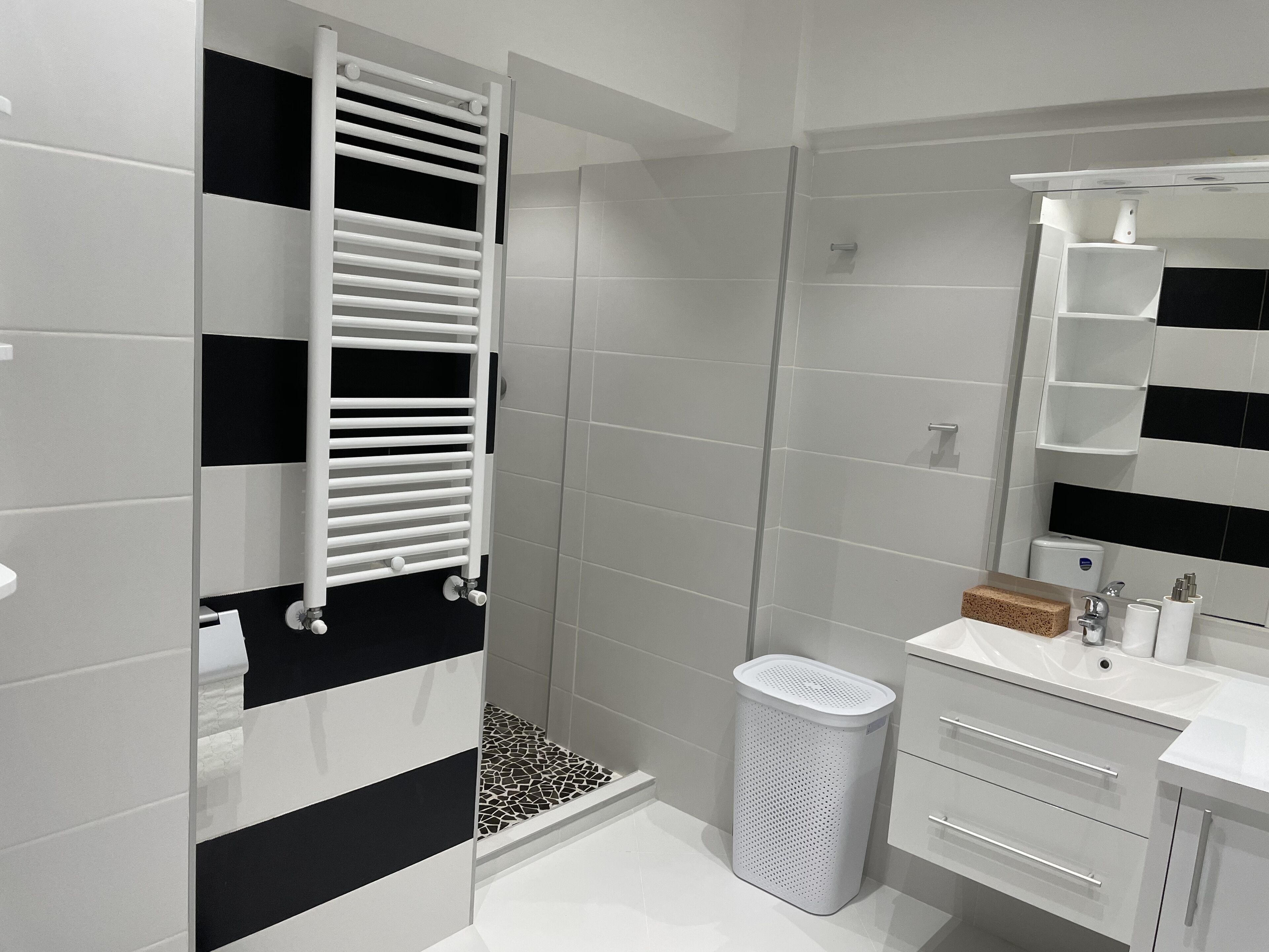 A modern bathroom with a shower, toilet, and sink.