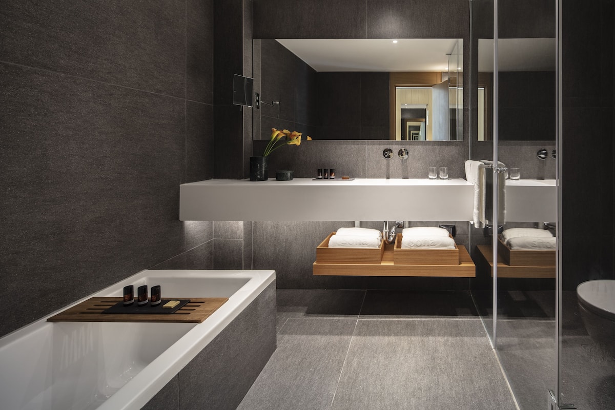 junior suite, lake view | bathroom | shower, hair dryer, slippers, towels