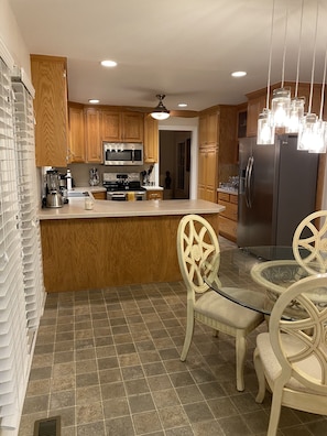 Enjoy a meal at the central island, surrounded by cabinetry and equipped with a refrigerator, microwave, and oven.