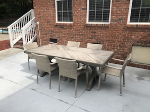 Enjoy dining or socializing in this outdoor patio area with a table and six chairs.