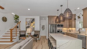 A modern kitchen with a marble island, wooden cabinets, and pendant lighting. - b6 sun and sand, B6 Oceanfront Ocean Lakes (Myrtle Beach)