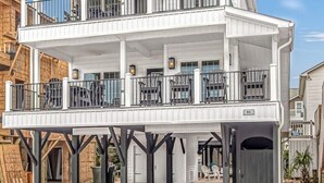 A two-story waterfront house with a covered porch and a balcony on the upper floor. - b6 sun and sand, B6 Oceanfront Ocean Lakes (Myrtle Beach)