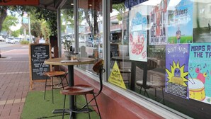 A cafe with outdoor seating, a chalkboard menu, and posters advertising local events. - Suite 26 |Town Central | Walk To Cafes | Sleeps 3 (Margaret River)