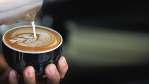 A person holding a cup of coffee with latte art. - Suite 26 |Town Central | Walk To Cafes | Sleeps 3 (Margaret River)