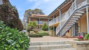 A building with a covered outdoor area, steps leading to a balcony, and a staircase. - Suite 26 |Town Central | Walk To Cafes | Sleeps 3 (Margaret River)