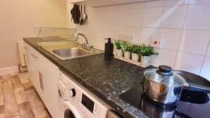 Eine kleine Küche mit Spüle, Herd und Geschirrgestell.