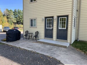 A two-story building with a front porch, two doors, and a covered grill.