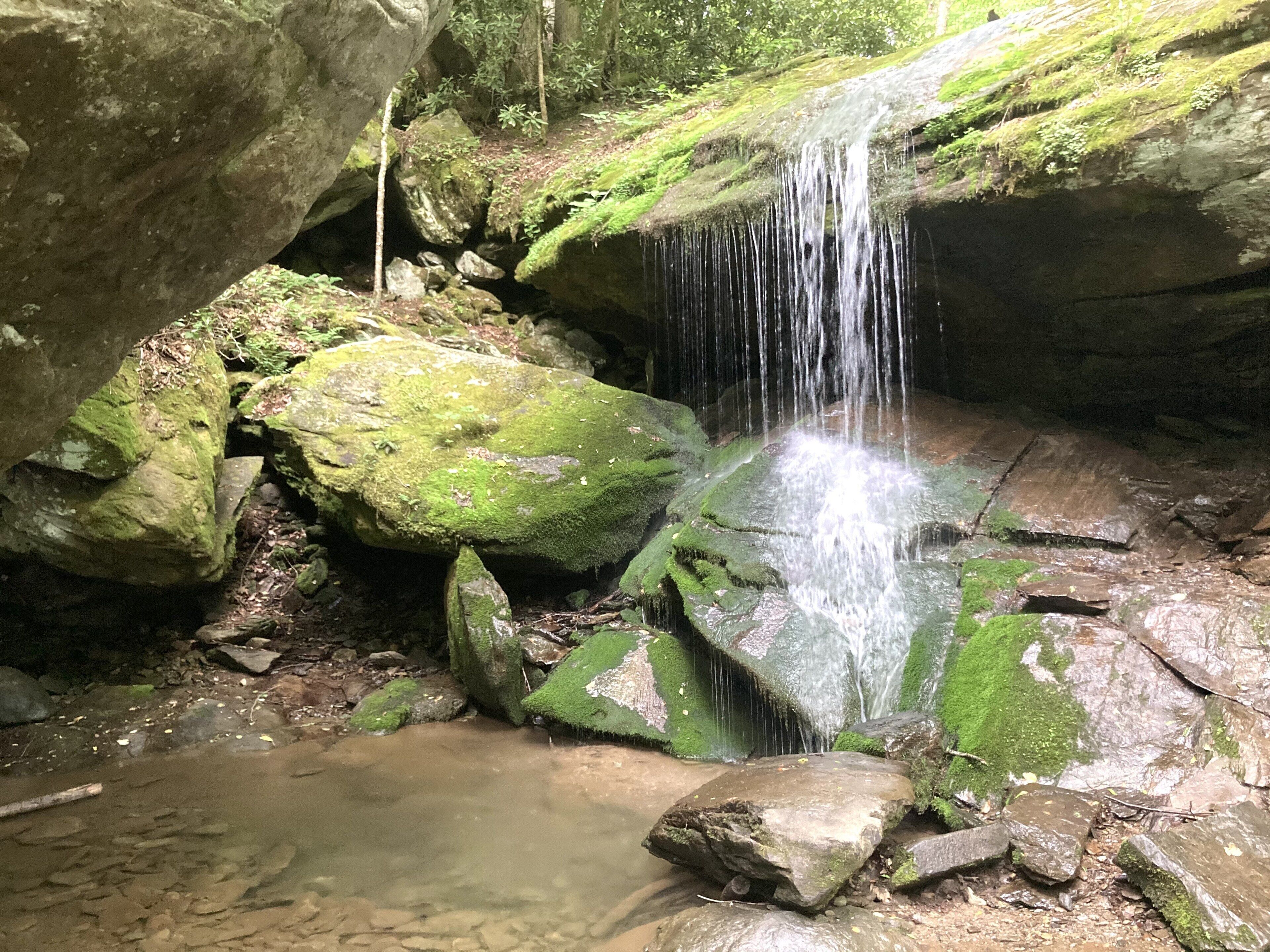 A natural rock formation with a waterfall.