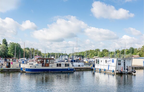 Boats docked at the serene marina, surrounded by lush trees.