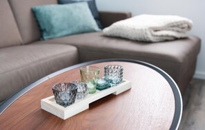 Relax in this stylish living room with a round coffee table and comfortable sofa.