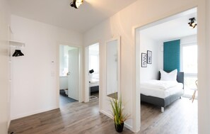 Relax in a serene space with a large bed, bedside table, and comfortable chair.