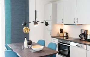 Enjoy cooking in this well-equipped kitchen with a dining table, pendant light, and modern appliances.