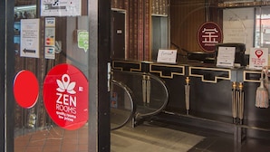 A hotel reception area with a sign for 'Zen Rooms' and a 'Jinshan' restaurant.