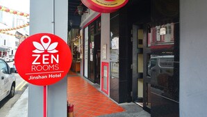 A hotel entrance with a red sign for Zen Rooms at Jinshan Hotel.