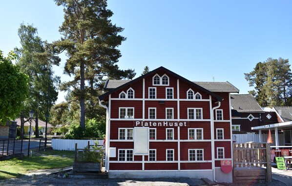 Ein rotes Gebäude mit weißem Zierrat und der Aufschrift "PlatenHuset" an der Fassade.