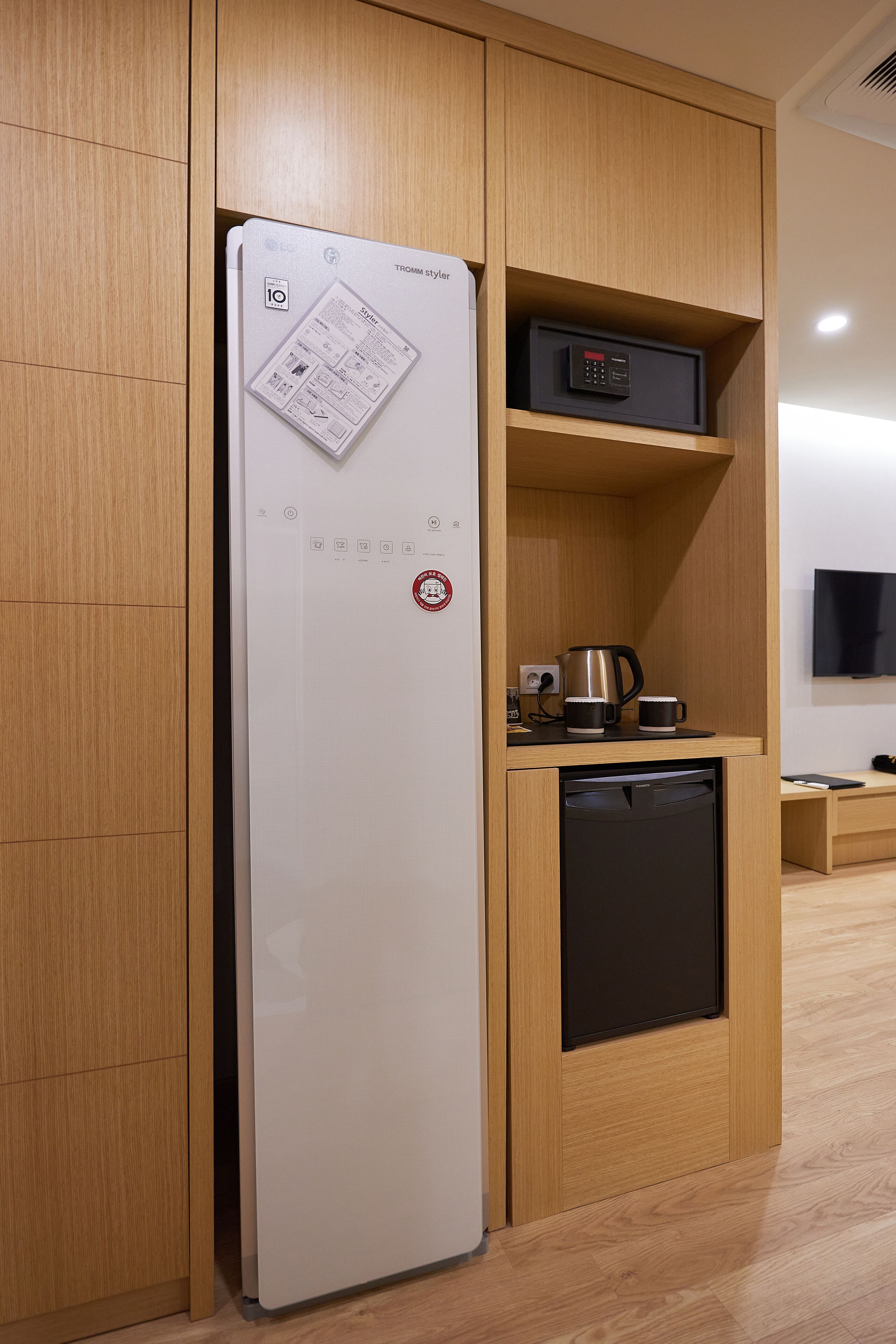 A compact kitchen with a white refrigerator, a coffee maker, and a dishwasher.