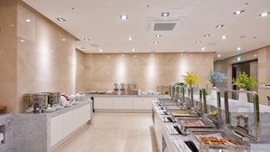 Een buffetruimte met meerdere food stations, een marmeren toonbank en een schoon, modern design.
