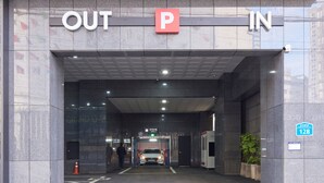 Entree van een parkeergarage met een duidelijk IN- en UIT-bord, een richtingswijzer en parkeerplaats nummer 128.