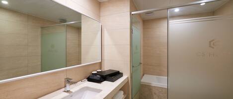 A modern bathroom with a large mirror, a sink, and a glass shower enclosure.