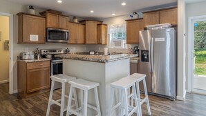 Una cocina moderna con armarios de madera, electrodomésticos de acero inoxidable y una encimera de granito.