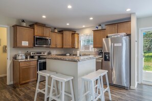 Una cocina moderna con armarios de madera, electrodomésticos de acero inoxidable y una encimera de granito.