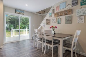 A dining area with a table, chairs, and a view of a balcony.