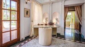 A room with a marble floor, a wooden door with glass panels, a white table with a bench, and a view of greenery outside. - Cozy home in Dénia with private swimming pool, can be inside or outside (Dénia)
